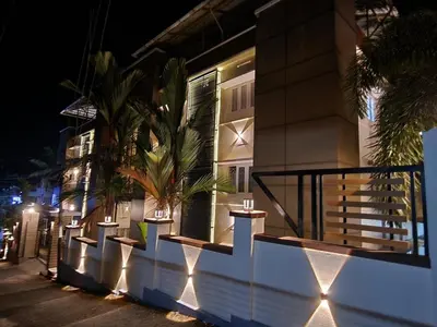 a building with lights on the side of it at night at Wayanad Cliff Hotel Apartments in Kalpetta