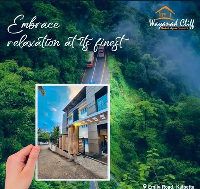 a hand holding a picture of a house in the forest at Wayanad Cliff Hotel Apartments in Kalpetta