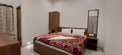 a bedroom with a bed with a dresser and a mirror at Anya Paradise in Ooty