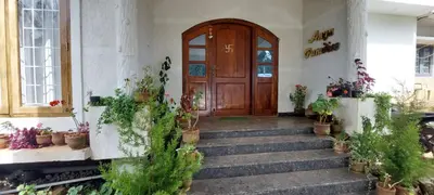 a entrance to a building with potted plants on the stairs at Anya Paradise in Ooty