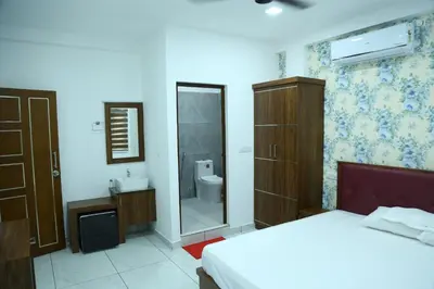 a bedroom with a bed and a sink and a mirror at Kurianplackal Residency in Alwaye