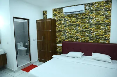 a bedroom with a bed and a stone wall at Kurianplackal Residency in Alwaye
