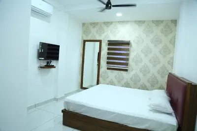 a bedroom with a white bed and a tv at Kurianplackal Residency in Alwaye