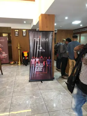 a sign in a lobby with people standing around at HOTEL JAAS CONTINENTAL in Edappāl