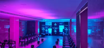 a room with pink and blue lights and chairs at HOTEL JAAS CONTINENTAL in Edappāl