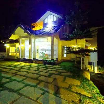 a house at night with the lights on at Wayanad Empire Colonial Villa in Kalpetta