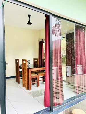 a dining room with a table and a window at Edenvilla in Vālpārai