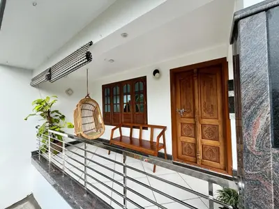 a balcony of a house with a bench and a basket at Springfield service villa in Mananthavady
