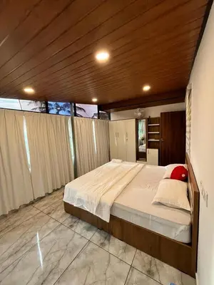 a bedroom with a large bed with a wooden ceiling at Springfield service villa in Mananthavady
