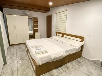 a bedroom with a large bed with white sheets at Springfield service villa in Mananthavady