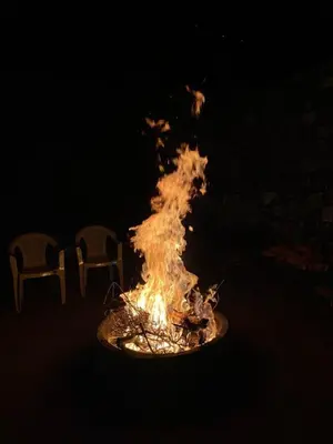 a fire pit with two chairs next to it at Moksha at Infinity Valley in Kotagiri