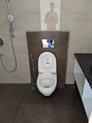 a bathroom with a white toilet and a shower at Moksha at Infinity Valley in Kotagiri