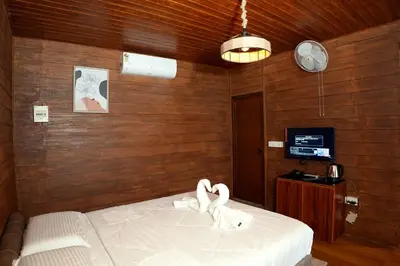 a bedroom with a bed with two swans on it at Mazhavilkadu ForestResort & Restaurant in Kozhikode