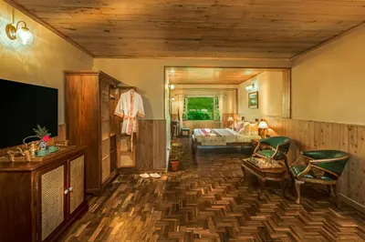 a living room with a television and a room with a couch at Willow Hill by Nature Resorts and Stays in Ooty
