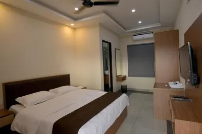a bedroom with a bed and a flat screen tv at ARAKKAL GUESTHOUSE in Kalpetta