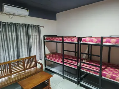 a room with two bunk beds and a bench at ARAKKAL GUESTHOUSE in Kalpetta