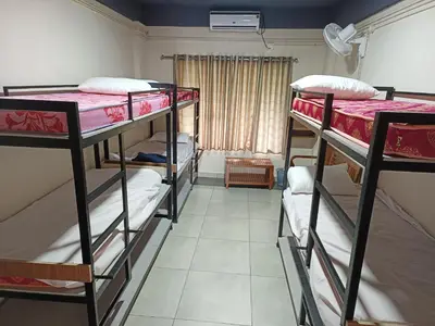 a room with three bunk beds and a window at ARAKKAL GUESTHOUSE in Kalpetta