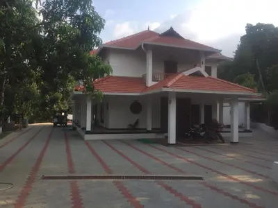 a white house with a red roof at Shilpa Vikas Homestay in Madikeri