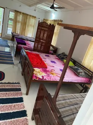 a room with a bed and a bunk bed at Shilpa Vikas Homestay in Madikeri