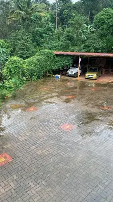 a flooded parking lot with a car parked in a garage at Shilpa Vikas Homestay in Madikeri