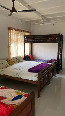 a bedroom with two beds and a bunk bed at Shilpa Vikas Homestay in Madikeri