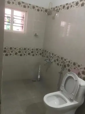 a bathroom with a toilet and a window at Shilpa Vikas Homestay in Madikeri