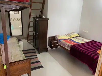 a bedroom with a bed and a bunk bed with a mirror at Shilpa Vikas Homestay in Madikeri