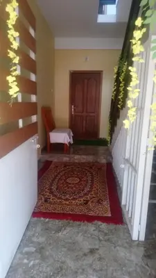a hallway with a door and a rug and a chair at CITY APARTMENTS in Guruvāyūr