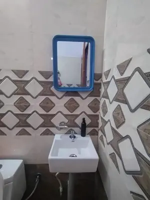 a bathroom with a sink and a mirror on a wall at CITY APARTMENTS in Guruvāyūr