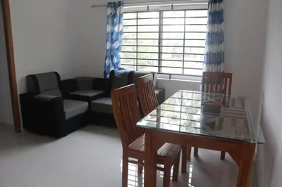 a living room with a table and chairs and a couch at CITY APARTMENTS in Guruvāyūr