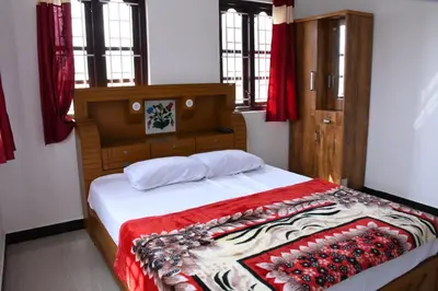 a bedroom with a bed with a red blanket on it at JDP Villa 2 Bhk House in Ooty