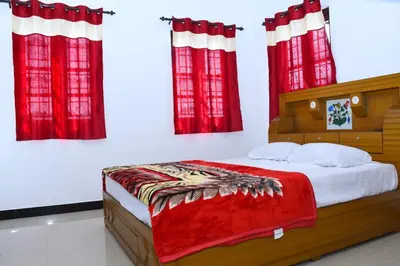 a bedroom with a bed with red curtains at JDP Villa 2 Bhk House in Ooty