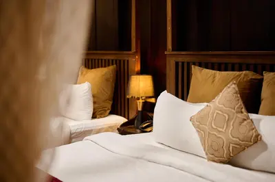 a bedroom with a bed with white sheets and pillows at Maliekal Heritance Cherai Beach Cochin in Cherai Beach