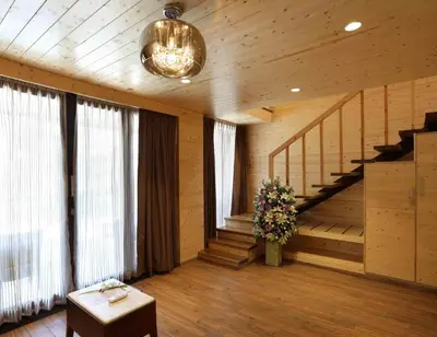 a living room with a staircase and a vase of flowers at Maliekal Heritance Cherai Beach Cochin in Cherai Beach