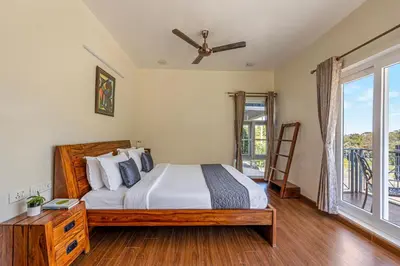a bedroom with a bed and a large window at Kalpavriksha 4BR Luxury Villa - Xplore Indo in Kotagiri