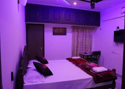 a purple room with a bed and a table at Malpans Mansion Villa in Nedumbassery