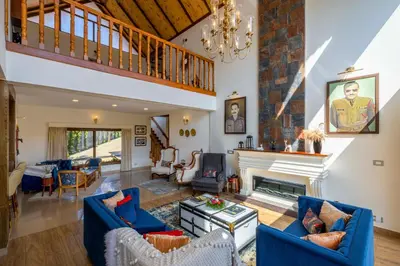 a living room with blue couches and a fireplace at amã Stays & Trails - Werifesteria, Coonoor in Coonoor