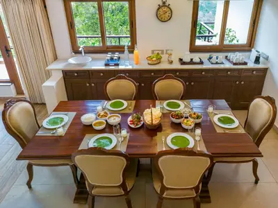 a wooden table with chairs around it in a kitchen at amã Stays & Trails - Werifesteria, Coonoor in Coonoor