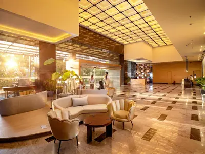 a lobby with a couch and chairs in a building at O by Tamara Coimbatore in Coimbatore