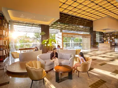 two women sitting in chairs in a lobby at O by Tamara Coimbatore in Coimbatore