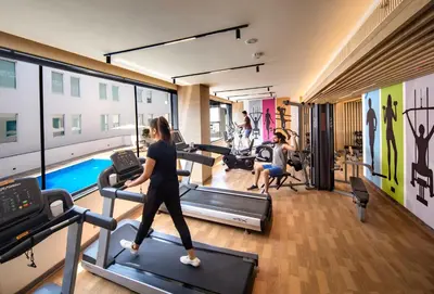a woman running on treadles in a gym at O by Tamara Coimbatore in Coimbatore