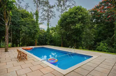a swimming pool with a table and a bench next to it at Misty Heights by The Sanihara in Vayittiri