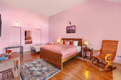 a bedroom with a bed and a chair in it at StayVista at 5 Rooms at The West Wind - Ooty Comp Breakfast in Ooty