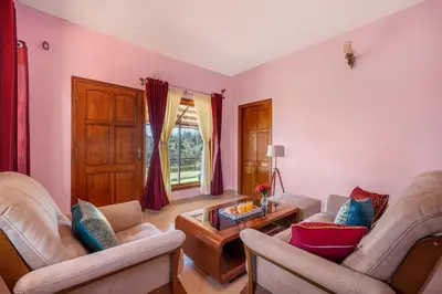 a living room with two couches and a table at StayVista at 5 Rooms at The West Wind - Ooty Comp Breakfast in Ooty