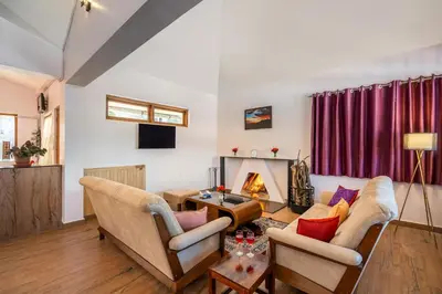 a living room with two couches and a fireplace at StayVista at 5 Rooms at The West Wind - Ooty Comp Breakfast in Ooty