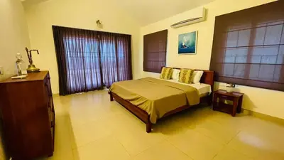 a bedroom with a large bed and a window at Seagrove Villa in Kappad