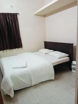 a bedroom with a large bed with white sheets and pillows at KUKAL CASTLE in Tiruppūr
