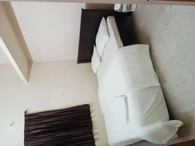 a bed with white pillows in a room at KUKAL CASTLE in Tiruppūr