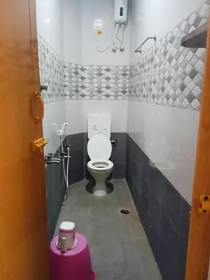 a bathroom with a toilet and a purple stool at KUKAL CASTLE in Tiruppūr