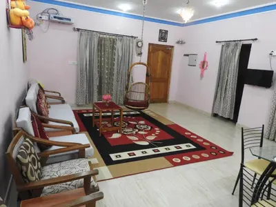 a living room with a rug on the floor at Shanthi Villa in Coonoor